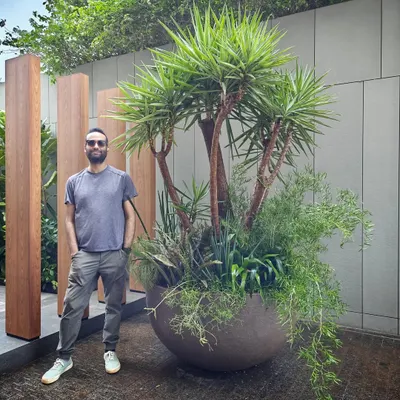 We love maximalism when it comes to plants. For a special client's birthday bash, we put together this overflowing, larger-than-life arrangement in just a couple of hours. Our co-founder Angud’s rare smile says it all.