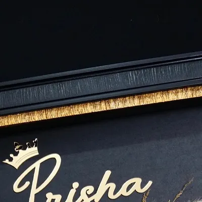 Personalization is key. Here you can see a close-up of the baby's name, 'Prisha', written in a beautiful script and topped with a little crown, all in a brilliant gold finish.