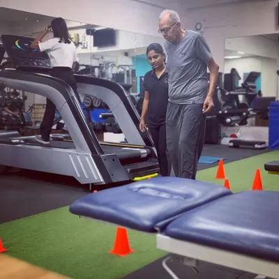 A client performs a guided exercise during a geriatric training session. We focus on controlled movements that build lower body strength and improve proprioception to prevent falls.