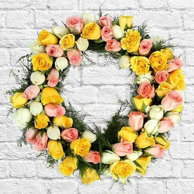 Beyond bouquets, I also create custom floral pieces like this beautiful wreath made of yellow, pink, and white roses. It's a perfect decorative element for special events, festive occasions, or as a heartfelt sympathy tribute.