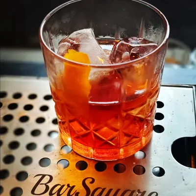 Crafting a perfect Negroni on our custom Bar Square drip tray. This cocktail represents the classic, balanced approach we bring to menu development.