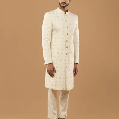 A side profile showcasing the flawless fit and drape of our custom sherwani. The delicate pastel embroidery adds a touch of modern refinement to this traditional garment for grooms.