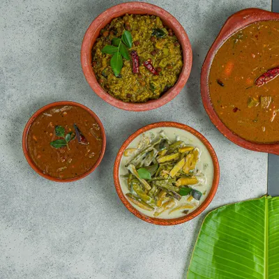 A comforting spread of South Indian curries, including a flavorful sambar, a coconut-based kootu, and a tangy rasam. Each dish is prepared using traditional family recipes and the freshest ingredients available.