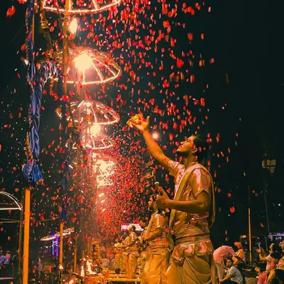 A priest showers flower petals during the grand Ganga Aarti on Dev Deepawali. This shot, with its vibrant colors and sense of motion, captures the celebratory essence of the ritual.