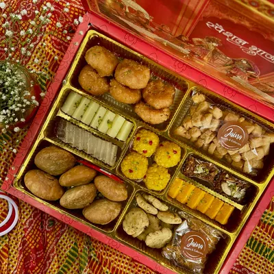 This is our fancy Bhaji Box, perfect for the Indian wedding season. It's packed with a variety of traditional sweets and savouries, including mathri, laddoos, and barfi, all arranged beautifully for gifting.