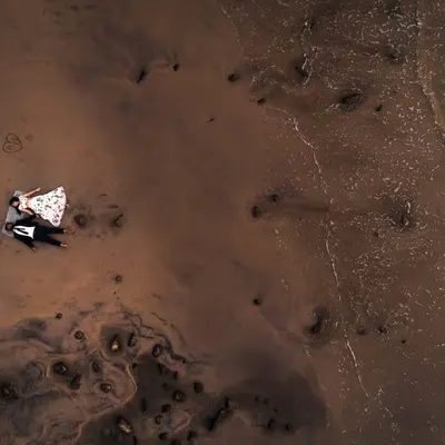 An aerial drone shot of Pulak and Manasi, finding stillness together as the waves kiss the shore. A truly epic perspective on a beach romance.