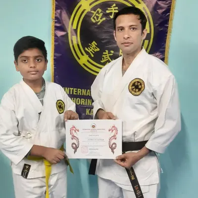 A student proudly holds his certificate after a successful grading examination. These events are an important part of our training, marking milestones in a student's journey and reinforcing the value of perseverance.