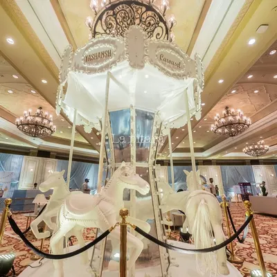 The magnificent carousel centerpiece in all its glory. This custom-built, all-white carousel with intricate detailing served as the breathtaking focal point for a magical, high-end birthday celebration.