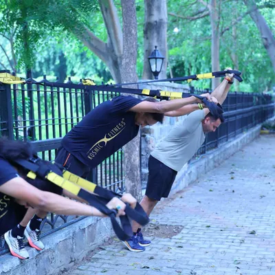 Our group using TRX bands for a challenging outdoor workout. This kind of training builds the core and upper body strength that runners often neglect.