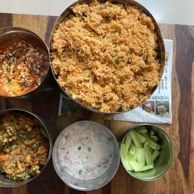 Vegetable pulao, matar paneer gravy and dry vegetable sabzi are ready with raita and salad for our 25-member anniversary order.