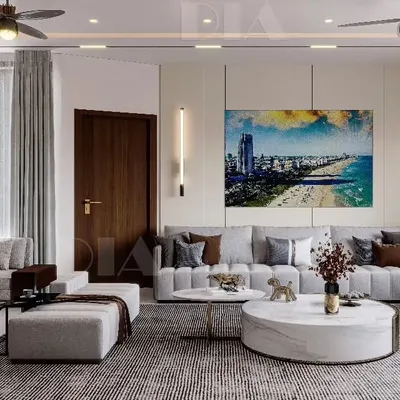 A showcase of contemporary living room design, featuring a large sectional sofa, a round marble center table, and carefully placed accent lighting. The space is designed to feel luxurious, warm, and calming.