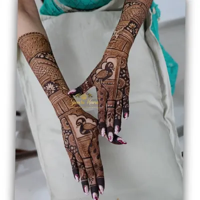 A heavy Indian back-hand design perfect for a bridesmaid, featuring bold peacocks and intricate fill-work that extends up the arm.