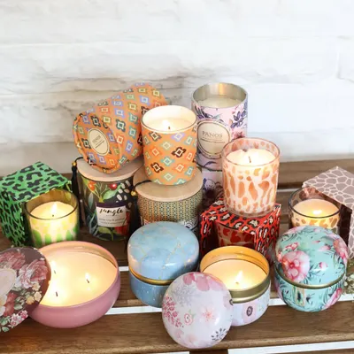 A beautiful assortment of our scented candles, showcasing the wide variety of designs we offer. From vibrant printed tins to elegant glass jars, there is a Panos candle to suit every style and mood.