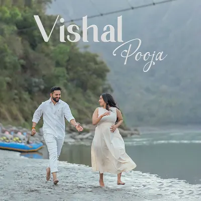 A playful chase along the sandy banks of the Ganga. This candid shot, with the suspension bridge in the background, perfectly captures the fun and carefree spirit of a Rishikesh pre-wedding shoot.
