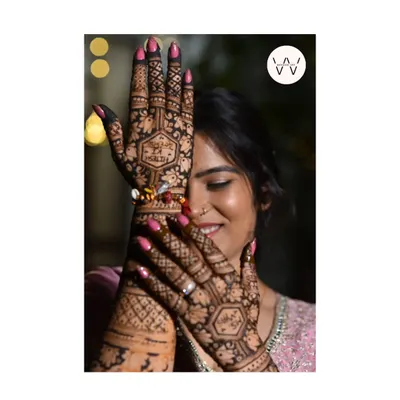 A happy client peeking through her beautifully hennaed hands.