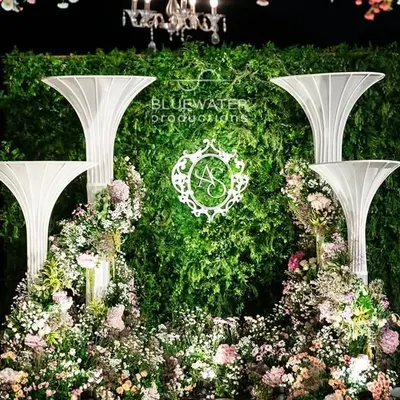 A detail of the floral and sculptural elements at the 'Blue Palace' reception, featuring a custom monogram against a living green wall.