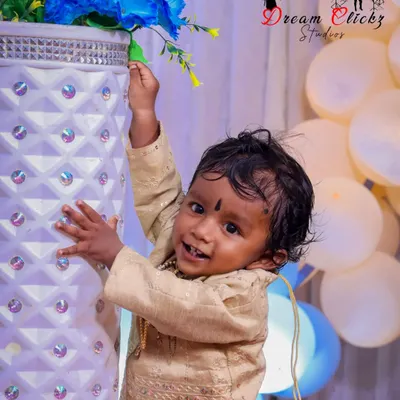 A happy baby boy enjoying his birthday photoshoot. His bright smile and curious hands reaching for the flowers show the playful energy I love to capture during these sessions.