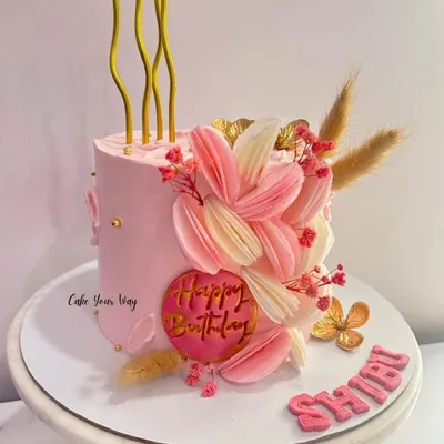 This cake is what dreams are made of. A tall, elegant pink cake with abstract floral details and delicate dried elements.