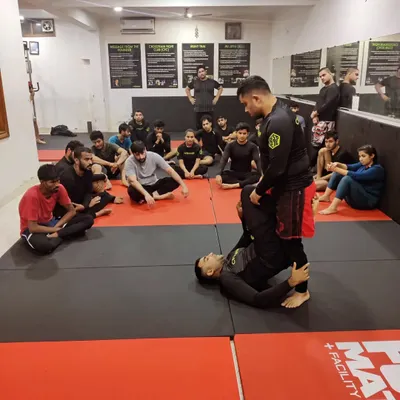 A coach provides one on one instruction for a student drilling a guard pass. We believe in giving personalized feedback to ensure every member understands the technique correctly.