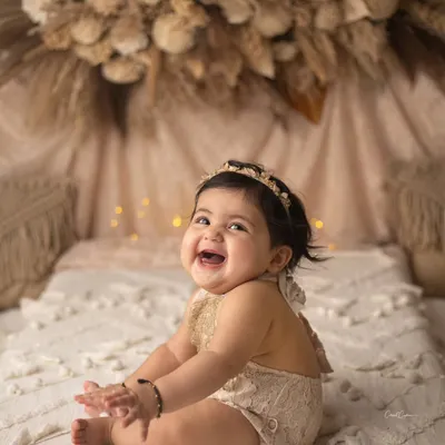 Bright eyes and a winning smile. This little one's happiness is absolutely contagious in this beautiful boho-themed sitter session.