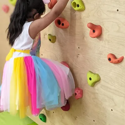 Dressed for a party but still ready to climb. Our indoor climbing wall is a safe and exciting way for children to build strength, coordination, and confidence as they plan their route to the top.