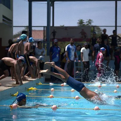 A swimmer executes a powerful racing dive, a fundamental technique we drill to ensure a fast and clean entry into the water during competitions.