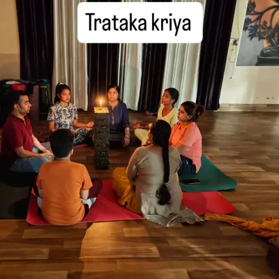 A group of students gathered for Trataka Kriya (candle gazing). The focused gaze on the flame helps to steady the mind, cleanse the eyes, and activate the Ajna Chakra, or third eye.