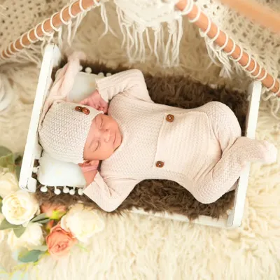 A full-length view of a newborn sleeping soundly in our boho-themed setup. We use cozy props like this miniature tent and soft furs to ensure the baby is comfortable and secure throughout the session.