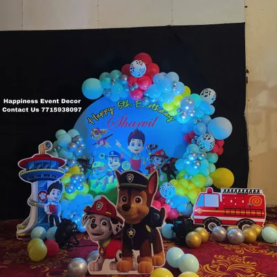 A complete Paw Patrol theme decoration for a 5th birthday. This setup includes a circular backdrop, character cutouts of Chase and Marshall, and other elements like the lookout tower.
