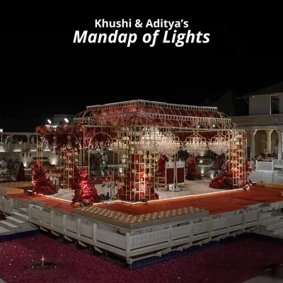 Khushi and Aditya's 'Mandap of Lights,' an opulent structure with a golden frame, cascading crystals, and rich red florals. This design created a royal and romantic ambiance for their nighttime ceremony.