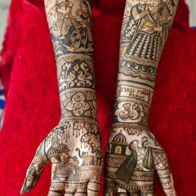 A full bridal design that combines divinity and family. One arm features a classic Radha-Krishna portrait, while the other has a custom portrait of the bride with her parents.
