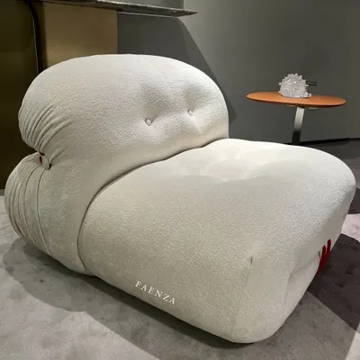 The Cloud Chair, an iconic piece designed for ultimate comfort. Upholstered in a soft, textured bouclé fabric, its billowy, low-slung form invites you to sink in and relax.
