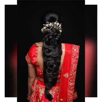 A stunning example of an intricate bridal braid. This hairstyle features multiple rose-shaped buns woven into the braid, creating a unique and highly detailed look for a bride.