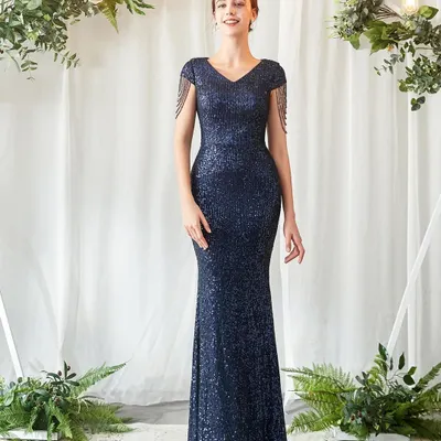 Look effortlessly chic at your next reception or formal event in this navy blue sequin gown. The figure-hugging silhouette and delicate tassel details on the shoulders add a touch of modern glamour.