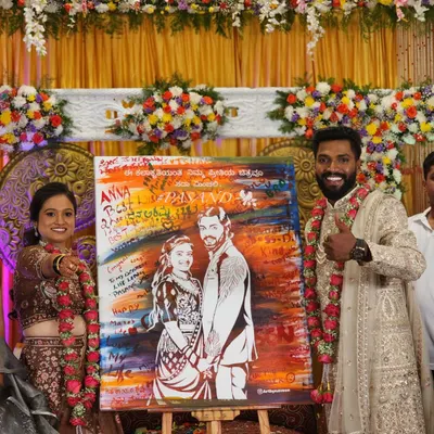 The final reveal is always a magical moment. This couple's smiles say it all as they hold their finished live wedding painting, complete with signatures and messages from their loved ones.
