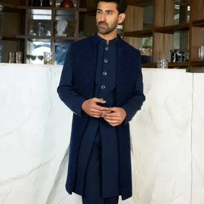A full-length view of a layered Indo-Western look in deep navy. The textured, sleeveless long jacket over a matching kurta set creates a sophisticated and modern silhouette.