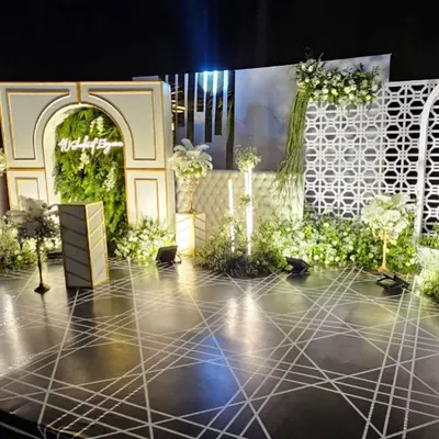 This custom stage backdrop combines a lush green wall, modern architectural arches, and a geometric floor design. It shows my commitment to creating unique and sophisticated settings for corporate galas and celebrations.