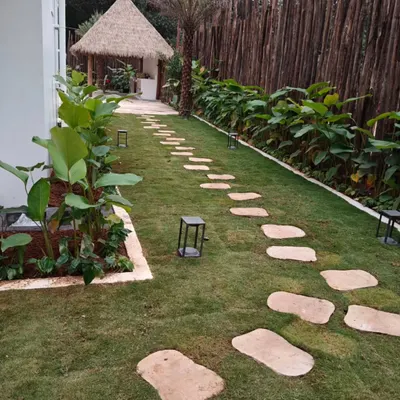 A perfect example of a finished garden featuring a healthy lawn, a winding stone path, and a rustic gazebo. The design creates a peaceful retreat right in the backyard.
