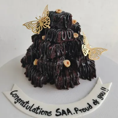 Introducing my Brownie Tower. This one was for a graduation celebration, decorated with gold butterflies and a custom "Congratulations" message. It's a fantastic centerpiece for any party.