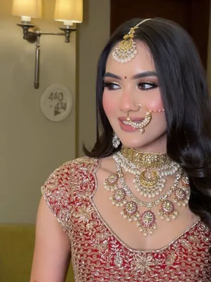 A candid moment that shows the beautiful side profile and the soft contouring. The pearl-detailed nath adds a touch of heritage to this classic bridal makeup style.
