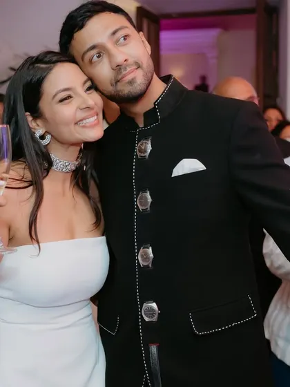 A sweet couple moment. Her makeup is fresh and party-ready, with a focus on luminous skin and a happy smile.