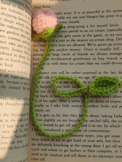 A pink tulip bookmark inside a book.