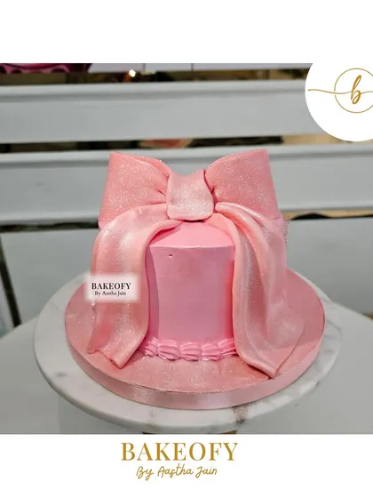 Indulge in elegance with this stunning pink bow cake. The velvet-textured fondant bow makes a beautiful statement on this simple, chic cake.