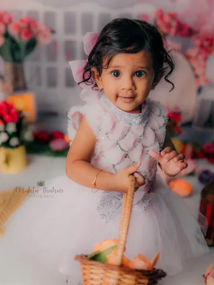 This little one is ready for a garden party. The basket of flowers and her sweet smile make for a perfect first birthday portrait.