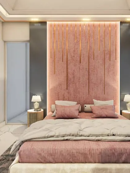A contemporary bedroom design featuring a soft pink, floor-to-ceiling upholstered headboard with integrated gold accent lighting. This creates a warm and gentle focal point, complemented by the marble-finish flooring and dark teal curtains.