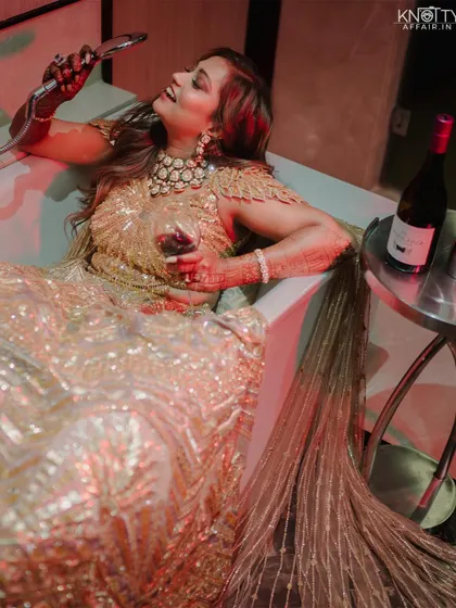 A fun and glamorous shot of the bride in her reception gown, posing in a bathtub with a glass of wine. This shows our creative and playful side.