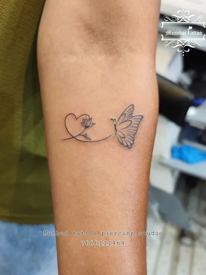 A delicate fine line tattoo combining a heart, a lotus, and a butterfly into one flowing design. This custom piece represents love, purity, and transformation, all woven together.