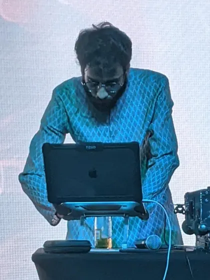 Focused on the laptop, queuing up the next track for the corporate party.