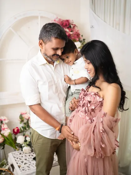 A heartwarming family moment. The older brother snuggles up to his parents, sharing in the excitement of the coming arrival.