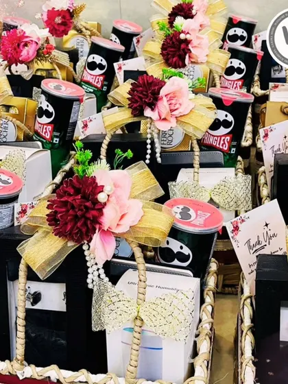 A glimpse into a large order of wedding favors. Each basket is carefully curated with snacks and gifts, adorned with floral arrangements and pearl strings to thank guests for their presence.
